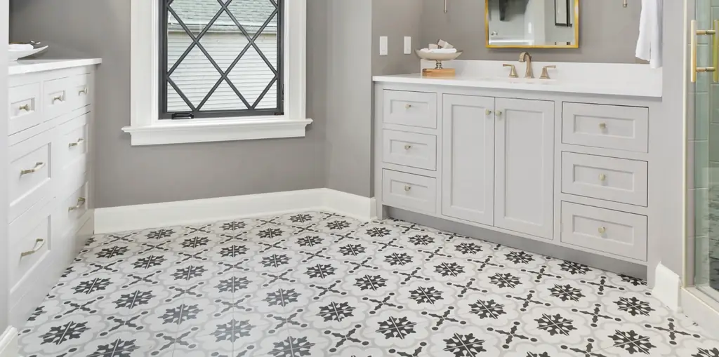 Bathroom floor finished in grey and white patterned tile, with a white vanity above it