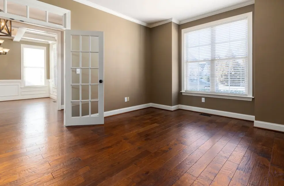 Home office with rich hardwood flooring installed throughout